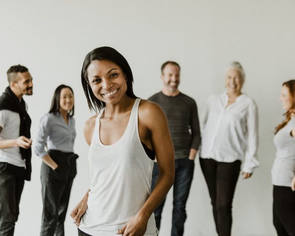 Confident black woman standing in front of her team